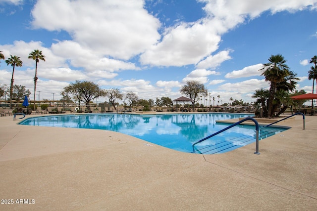 community pool with a patio and fence