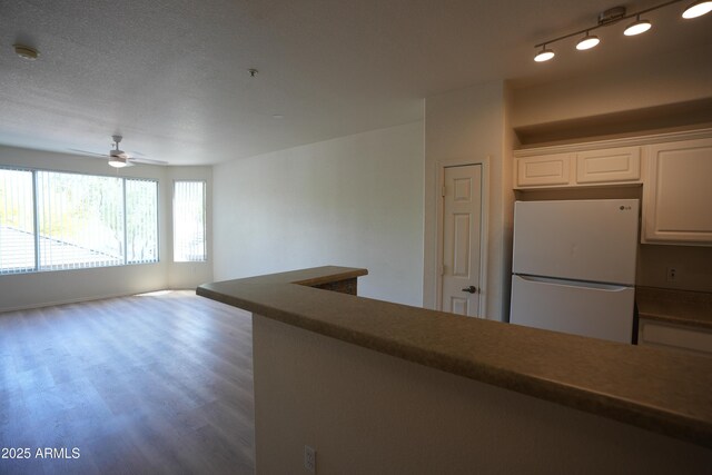 435 W Rio Salado Pkwy Unit 210, Tempe, AZ 85281 - kitchen with dark countertops, freestanding refrigerator, white cabinetry, a ceiling fan, and wood finished floors