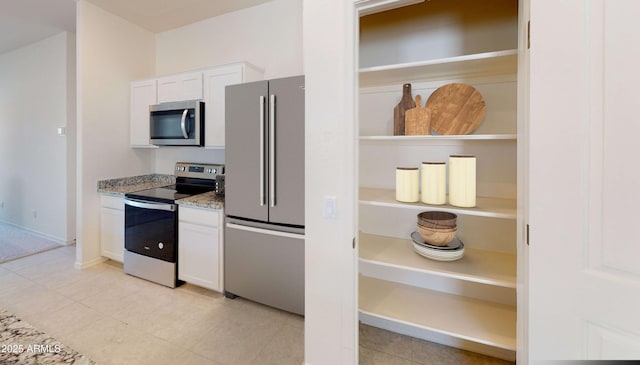 kitchen featuring white cabinetry, stainless steel appliances, and light stone counters