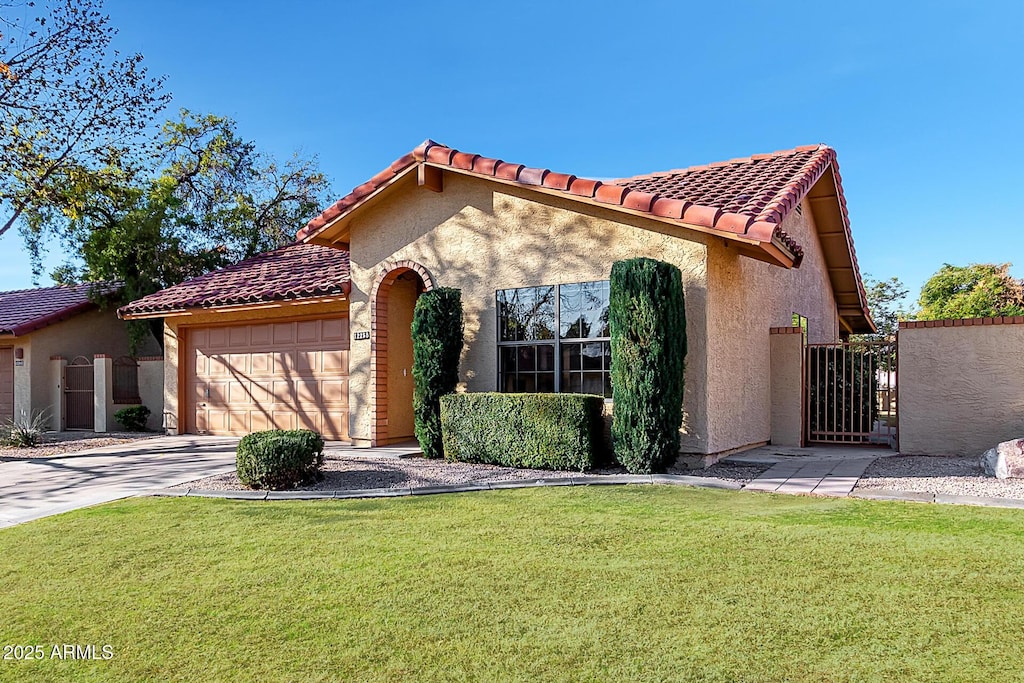 mediterranean / spanish house with a garage and a front yard