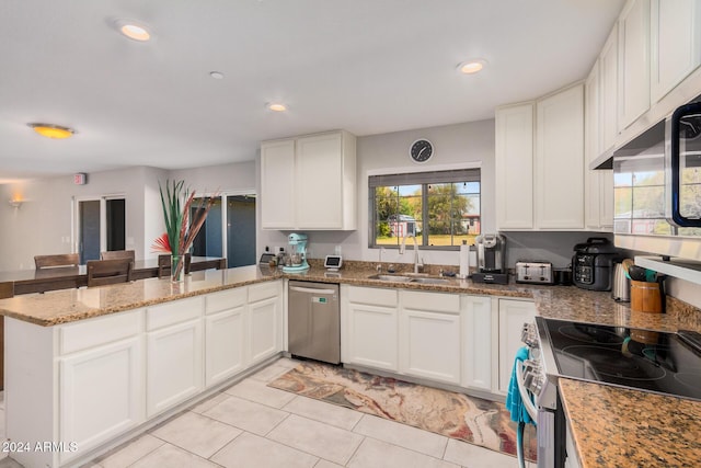 kitchen with sink, light tile patterned floors, appliances with stainless steel finishes, white cabinetry, and kitchen peninsula