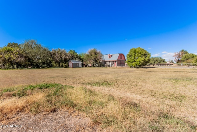 view of yard with a rural view and a shed