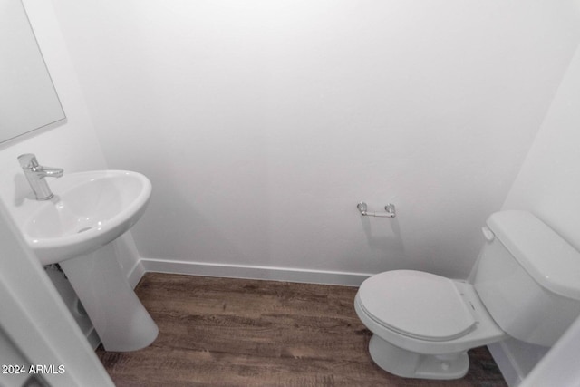 bathroom with hardwood / wood-style floors and toilet