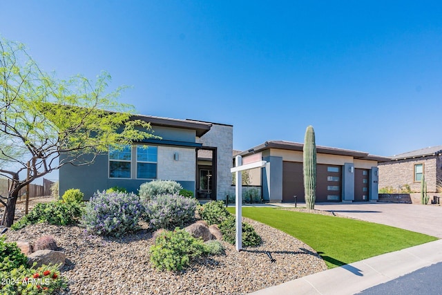 contemporary home with a garage and a front yard