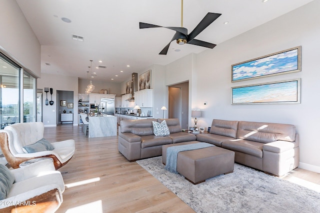 living room with light wood-type flooring and ceiling fan