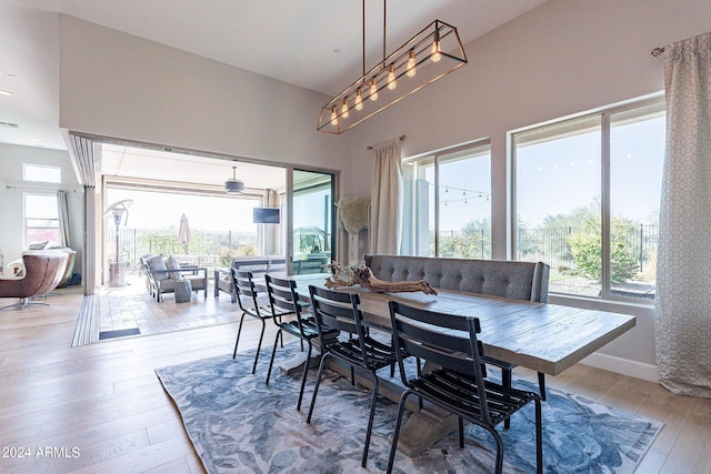 dining space with light wood-type flooring and a high ceiling