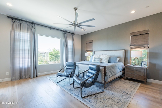 bedroom with multiple windows, ceiling fan, and light hardwood / wood-style flooring