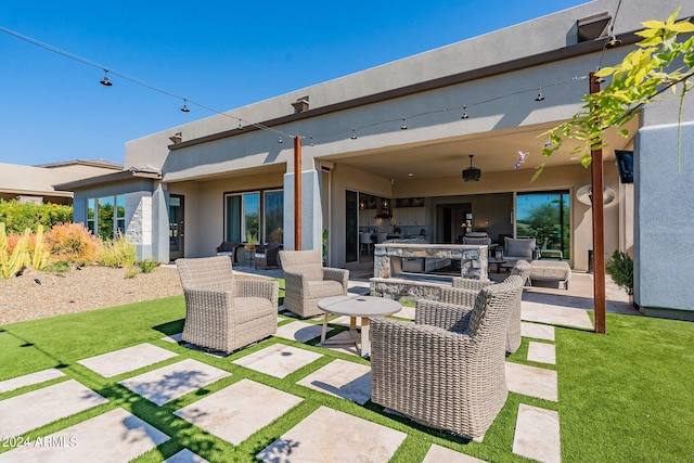 rear view of property featuring outdoor lounge area, a yard, and a patio area