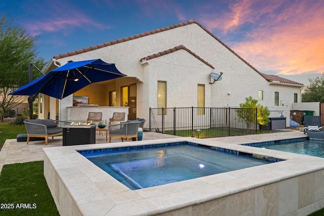 16987 W Princeton Ave, Goodyear, AZ 85395 - pool at dusk featuring outdoor lounge area, a patio area, and a pool with connected hot tub