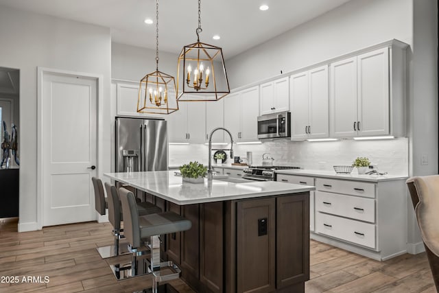 16987 W Princeton Ave, Goodyear, AZ 85395 - kitchen with high quality appliances, light countertops, decorative backsplash, a chandelier, and a kitchen bar