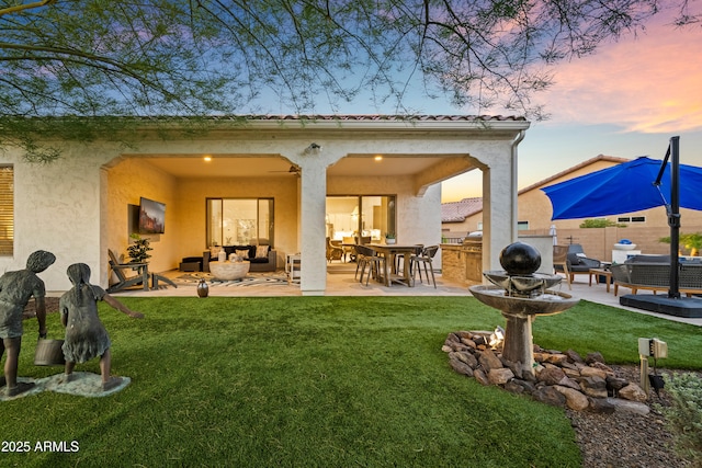 16987 W Princeton Ave, Goodyear, AZ 85395 - back of property at dusk featuring outdoor lounge area, a patio, and stucco siding