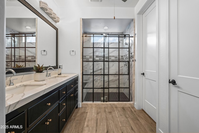 16987 W Princeton Ave, Goodyear, AZ 85395 - full bathroom featuring wood finished floors, double vanity, a stall shower, and healthy amount of natural light