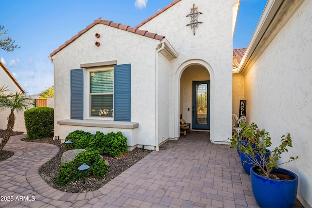 16987 W Princeton Ave, Goodyear, AZ 85395 - view of exterior entry featuring stucco siding, a tile roof, and a patio