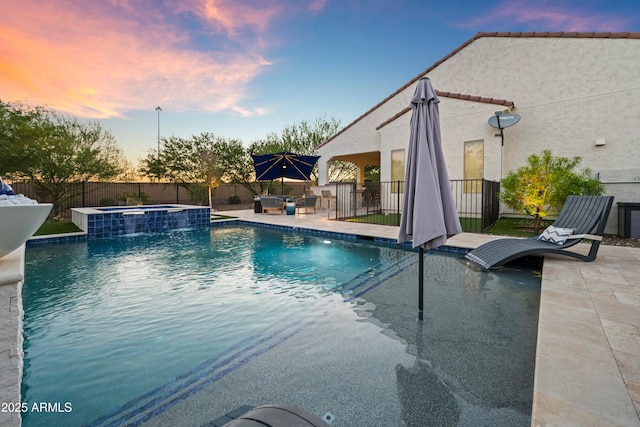 16987 W Princeton Ave, Goodyear, AZ 85395 - pool at dusk with an outdoor hot tub, a patio, and a fenced backyard
