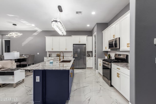 kitchen with white cabinets, appliances with stainless steel finishes, sink, and a notable chandelier