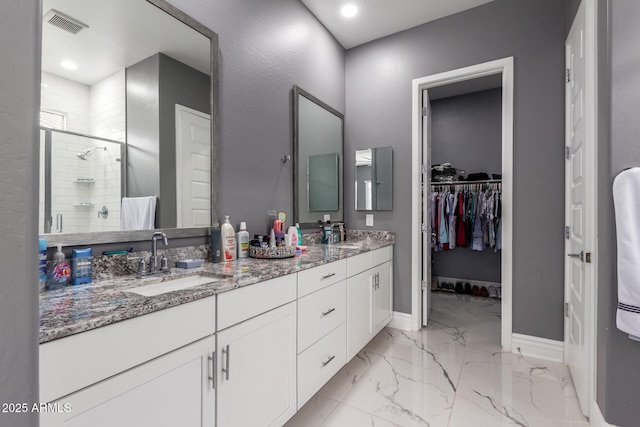 bathroom with vanity and a shower with door