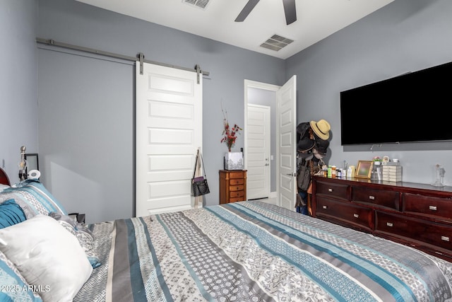 bedroom featuring a barn door and ceiling fan