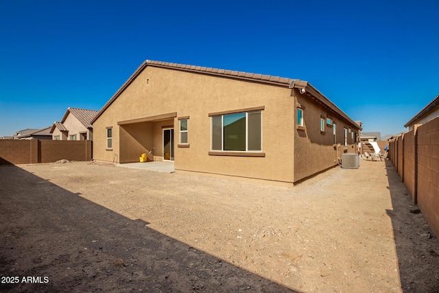 rear view of house featuring central AC unit and a patio