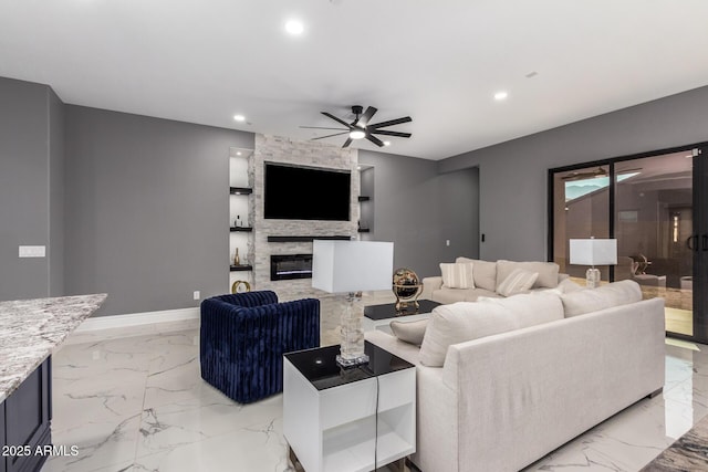 living room featuring a stone fireplace and ceiling fan