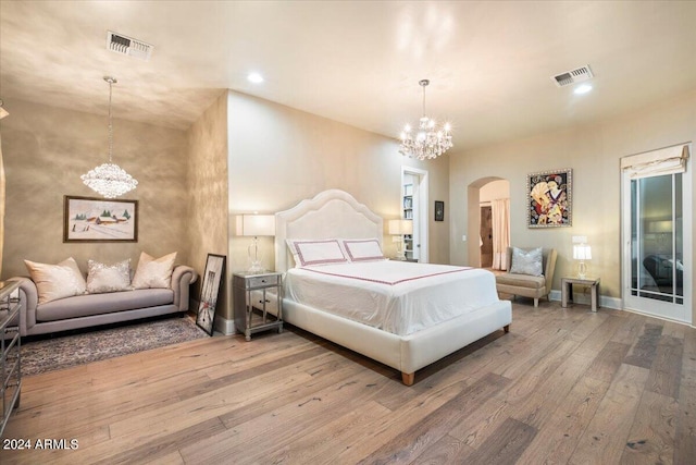 bedroom with light hardwood / wood-style flooring and a notable chandelier