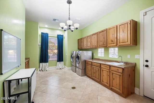 clothes washing area with a healthy amount of sunlight, sink, cabinets, and independent washer and dryer