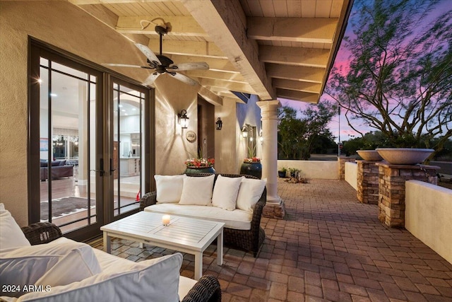 patio terrace at dusk featuring ceiling fan and an outdoor hangout area