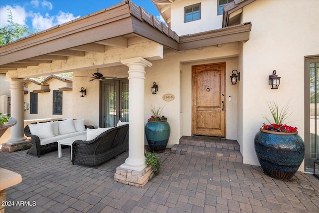 entrance to property with a patio area, ceiling fan, and an outdoor hangout area