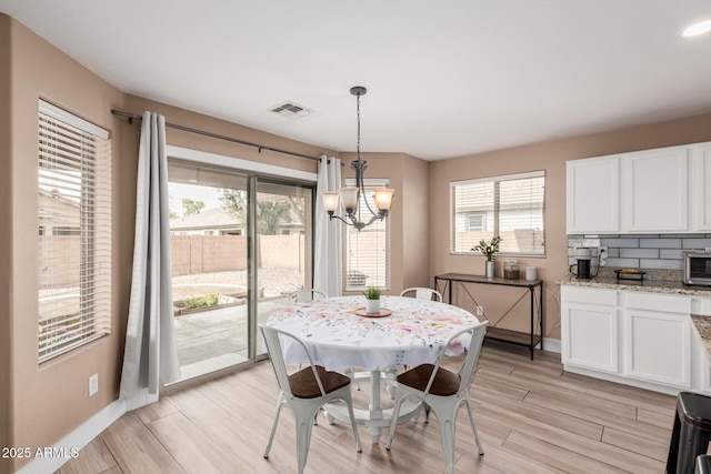 22337 E Via Del Palo, Queen Creek, AZ 85142 - dining area featuring a wealth of natural light, visible vents, an inviting chandelier, and light wood-style floors