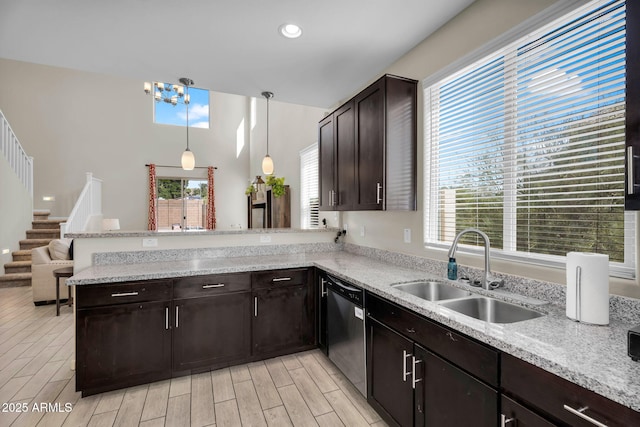 kitchen with dishwasher, a peninsula, wood tiled floor, dark brown cabinets, and a sink