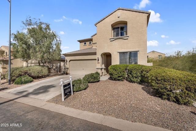 mediterranean / spanish house featuring driveway, an attached garage, and stucco siding