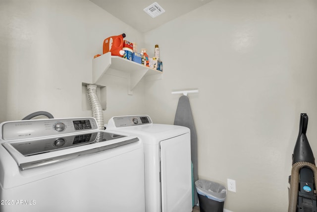 laundry room with laundry area, washing machine and dryer, and visible vents