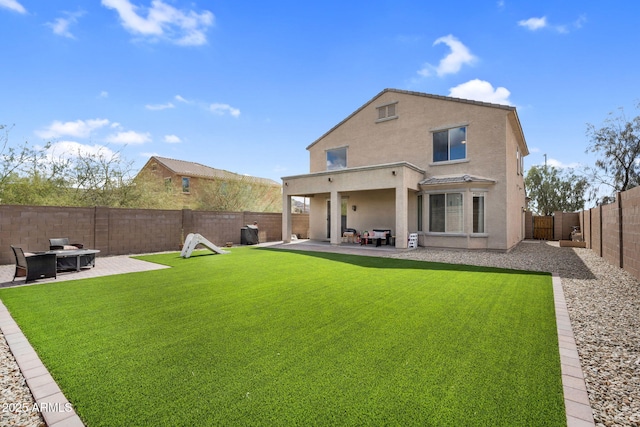 back of house featuring a patio area, a fenced backyard, a lawn, and stucco siding