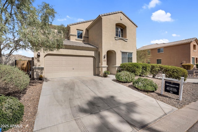 mediterranean / spanish-style house with driveway, a garage, fence, and stucco siding