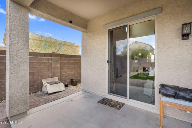 entrance to property with a patio area and stucco siding