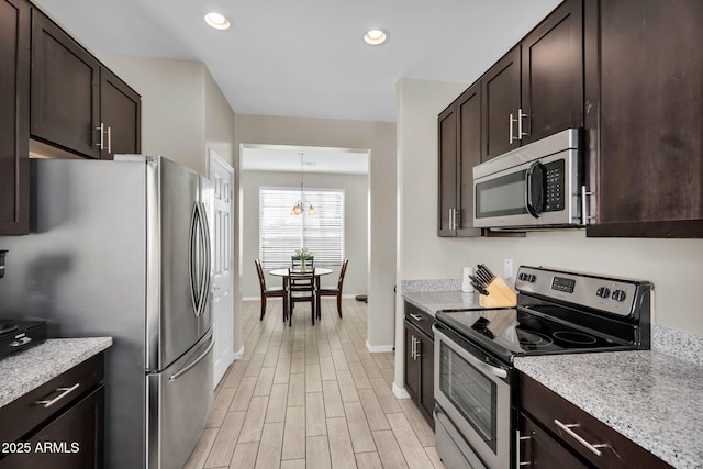 kitchen featuring appliances with stainless steel finishes, light wood-style flooring, and dark brown cabinets