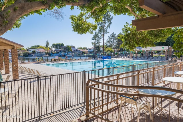 view of pool with a water view and a patio area