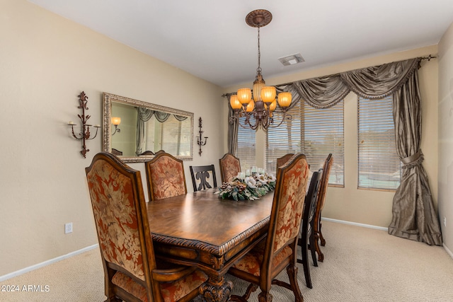 dining space with carpet and a chandelier