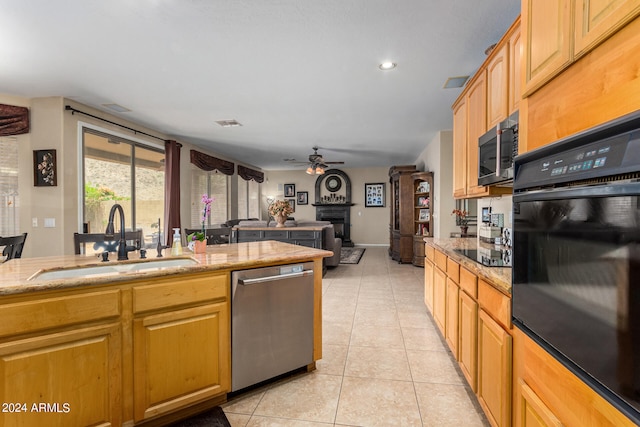 kitchen with black appliances, ceiling fan, sink, and light tile patterned floors