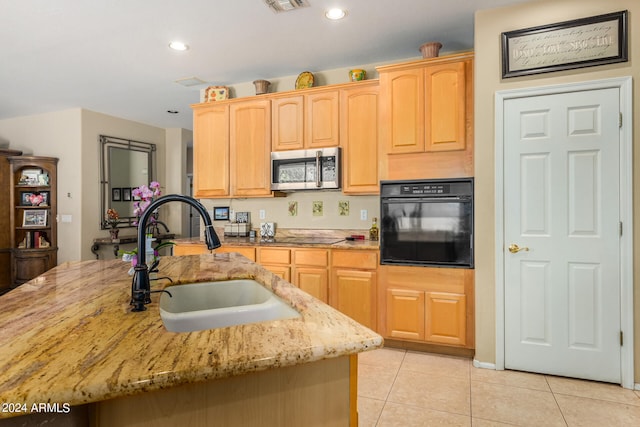 kitchen with black oven, light tile patterned floors, light brown cabinetry, and sink