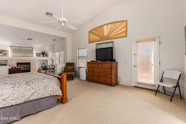 carpeted bedroom featuring access to exterior, ceiling fan, high vaulted ceiling, and a tile fireplace