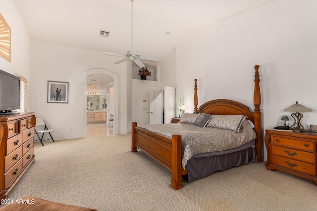 carpeted bedroom featuring a high ceiling, ceiling fan, and connected bathroom