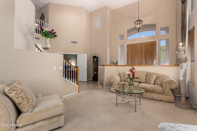 living room featuring a high ceiling, light colored carpet, and a notable chandelier