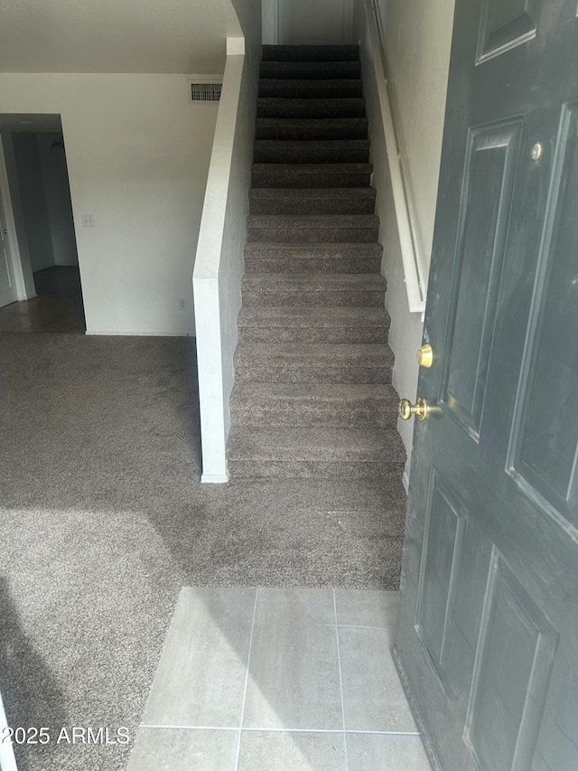 staircase featuring carpet flooring