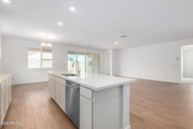 kitchen featuring sink, dishwasher, a notable chandelier, light hardwood / wood-style floors, and a center island with sink