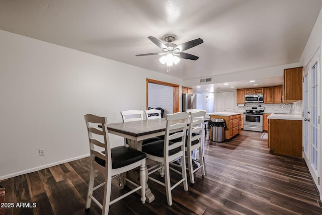 dining area with dark hardwood / wood-style flooring, sink, and ceiling fan