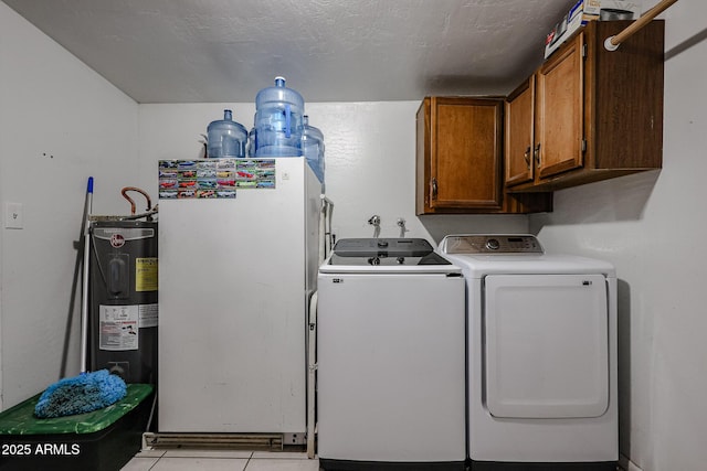 laundry room with cabinets, a textured ceiling, electric water heater, and washing machine and clothes dryer