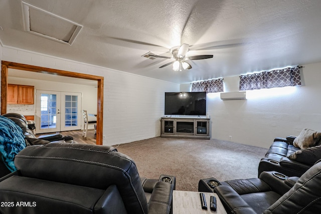 carpeted living room with ceiling fan, french doors, a textured ceiling, and brick wall