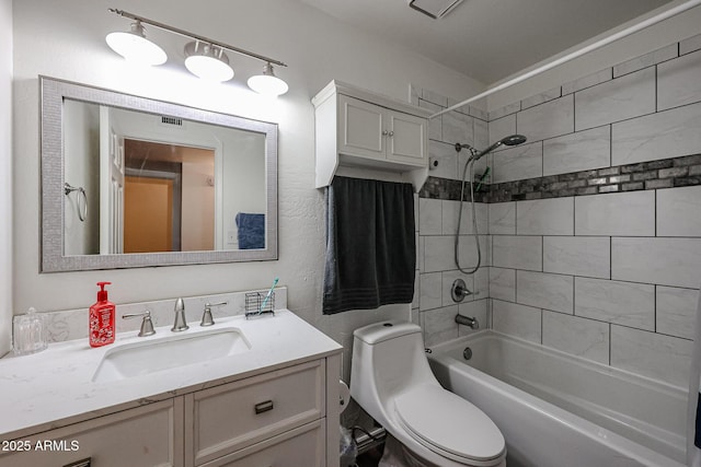 full bathroom with tiled shower / bath, vanity, and toilet