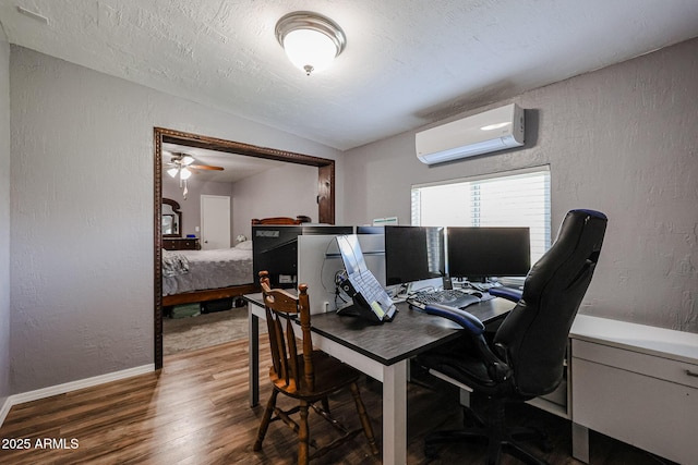 office area featuring a wall mounted AC, hardwood / wood-style floors, and a textured ceiling