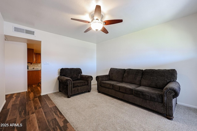 living room featuring dark hardwood / wood-style flooring and ceiling fan